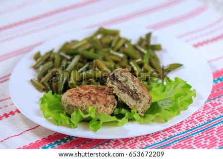 Cutlets with a stuffing with a garnish on a white plate on a light background