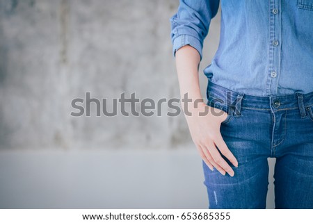 Closeup woman casual outfits standing and denims holds his hands in pockets. Concrete background with space for texture. woman beauty and fashion concept, Jeans concept