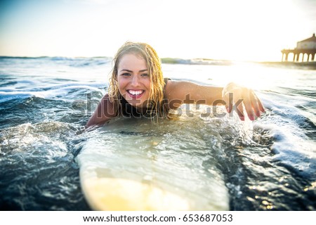 Woman surfing in the ocean Royalty-Free Stock Photo #653687053