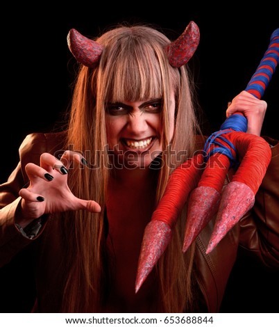 Girl devil threatens with a trident on a black background
