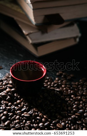 coffee cup and coffee beans on the background of books.