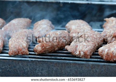 Grilled mititei/mici (traditional Romanian meat dish similar to cevapcici) on oven grill