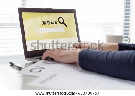 Man trying to find work with online job search engine on laptop. Jobseeker in home office. CV and application paper on table. Motivated applicant. Modern job hunting, seeking and unemployment concept. Royalty-Free Stock Photo #653700757