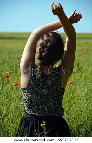 Young ballerina with braided hair in a wheat field