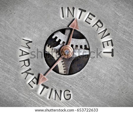 Macro photo of pointer and tooth wheel mechanism with INTERNET MARKETING letters imprinted on metal surface