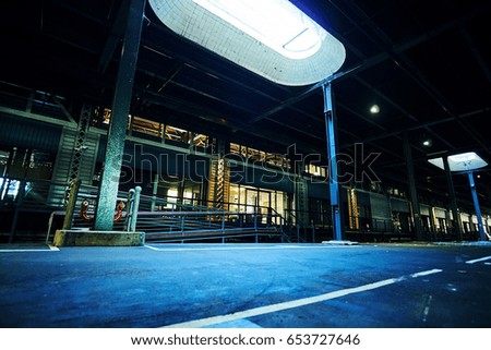 Generic warehouse store with dramatic lighting in parking lot, empty floor with retail shop