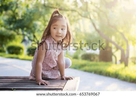 The lovely girl was sitting happily on the park bench