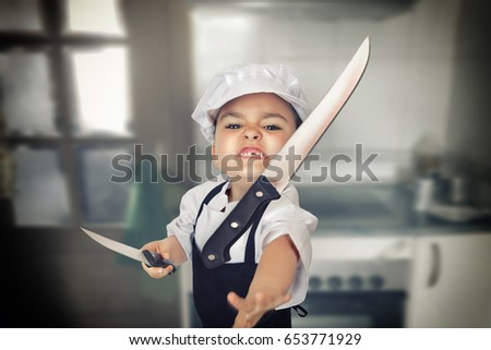 Funny portrait of a six years girl dressed as a cook throwing a knife