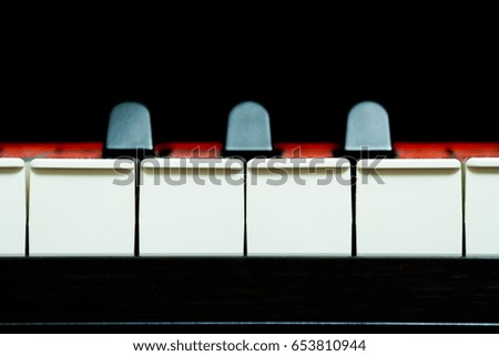Piano keys front view on a black background (closeup, copyspace)