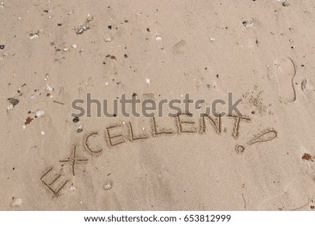 Handwriting  words "EXCELLENT!" on sand of beach.