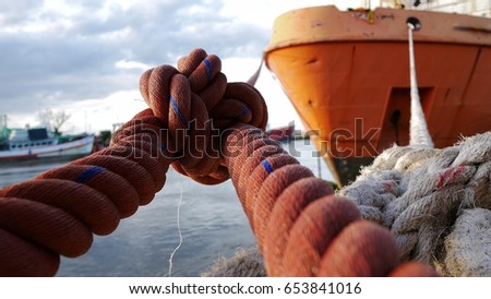 Mooring ropes, The vessel is moored alongside a big ship Royalty-Free Stock Photo #653841016
