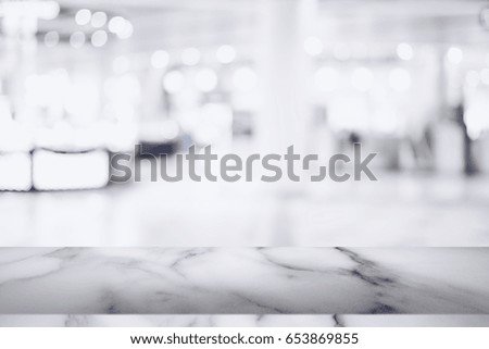 Empty white marble table with blur shopping mall background. For display or montage your products.