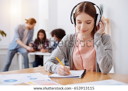 Attentive productive young student making a transcript Royalty-Free Stock Photo #653913115
