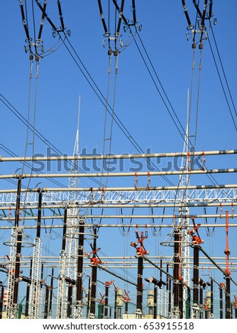 High voltage power substation on blue sky background.