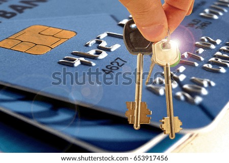 	The keys to the house in the background of the credit card .