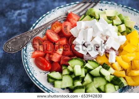 Fresh delicious tomato, bell pepper, cucumber, avocado, onion and feta salad