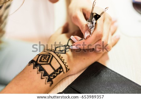 Picture of human hand being decorated with henna. mehendi hand