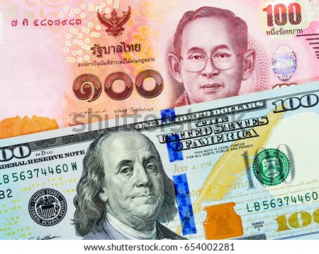 THB and US dollar bank notes concept business background. Close up view of US Dollar and THB bills. currency exchange rate. Background with money american dollar and Thai baht banknote Royalty-Free Stock Photo #654002281