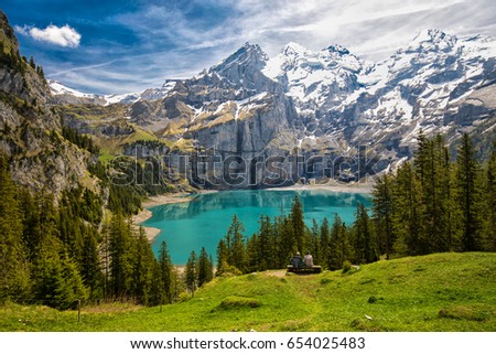 Amazing tourquise Oeschinnensee with waterfalls, wooden chalet and Swiss Alps, Berner Oberland, Switzerland.  Royalty-Free Stock Photo #654025483