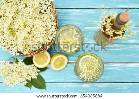 Two glasses of elderflower lemonade and bottle of homemade syrup, top view Royalty-Free Stock Photo #654065884