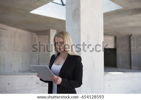 Happy businesswoman holding a digital tablet.