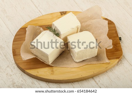 Feta cheese with dill over wooden background