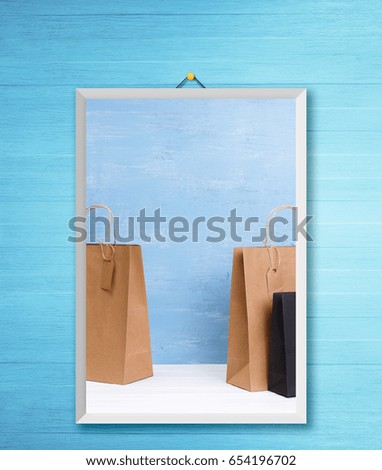 Mockup of blank shopping bags. Brown and black craft packages. Concept for sales or discounts. Recycled paper. Blue wooden rustic board. Photo frame on wooden rustic wall.