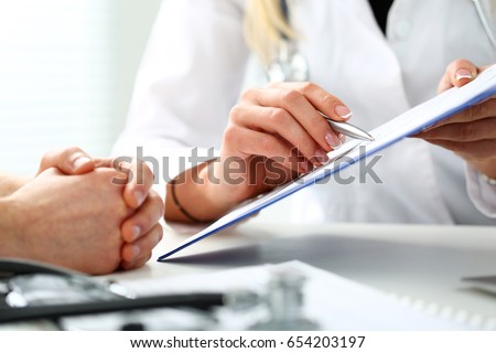 Female doctor hand hold silver pen and showing pad. Physical agreement form signature, disease prevention, ward round reception, consent contract sign, prescribe remedy, healthy lifestyle concept Royalty-Free Stock Photo #654203197