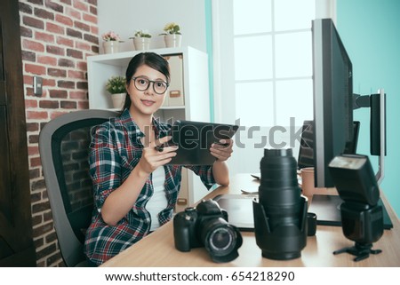 sweet attractive photo stock company female office worker holding mobile digital tablet computer checking photographer business picture and looking at camera smiling.