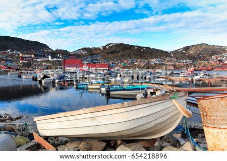 boats sit moored at the city habor. trading port with its docks more recently undergoing  qaqortoq greenland