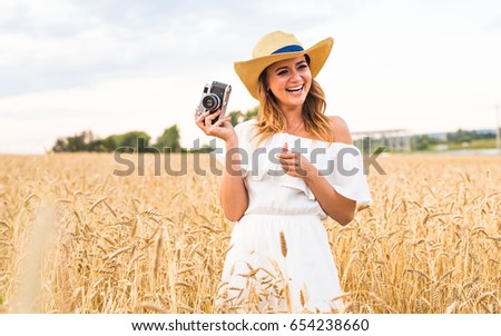Portrait of a pretty young woman taking photographs with vintage retro camera