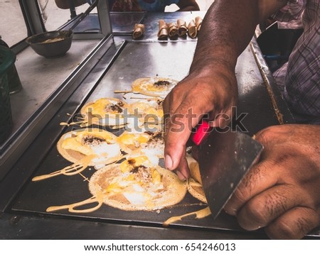 Men are making to roll pancake stuffed with pork and eggs
