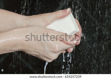 Woman hand closeup with bar of soap in the shower