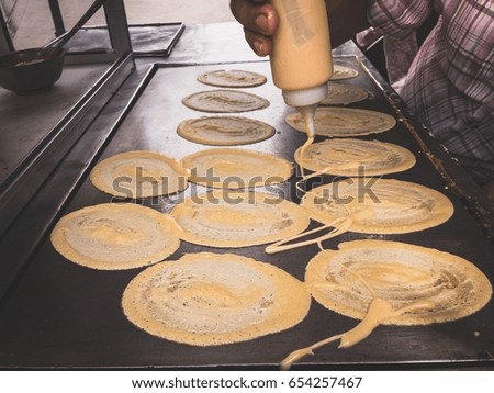 Men are making to roll pancake stuffed with mustard