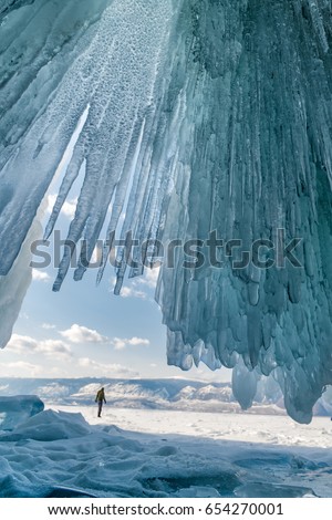 Transparent blue icicle ice cave in Lake Baikal  Royalty-Free Stock Photo #654270001