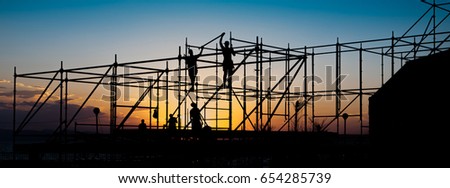 Construction workers working on scaffolding. Royalty-Free Stock Photo #654285739
