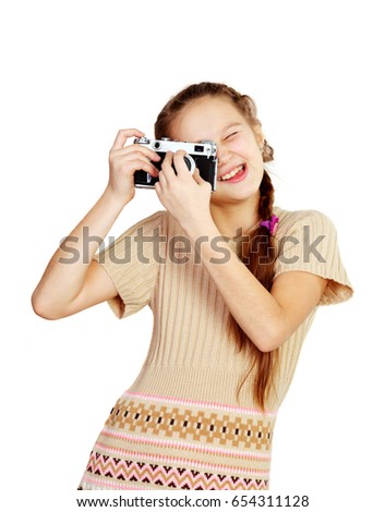 Little girl photographer holding camera and taking picture on white background