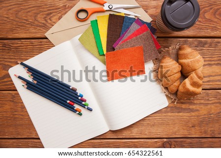 Workplace of fashion designer. Pencils, coffee and fabrics top view. Creative background, art school, sewing inspiration and idea concept
