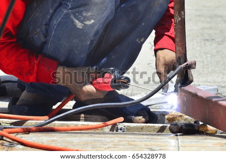Worker welding steel bars at construction site outdoor