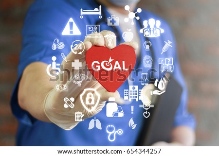 GOAL Health Care. Target in medicine treatment. Medical Success Strategy Plan Concept. Purpose achievement in hospital work. Doctor offers heart with goals icon on virtual screen. Healthy life style.