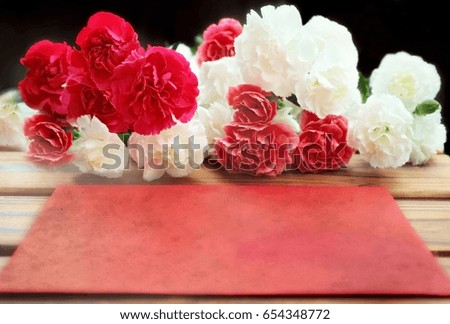 Greeting cards background. Carnations bouquet and red envelop on wooden background.