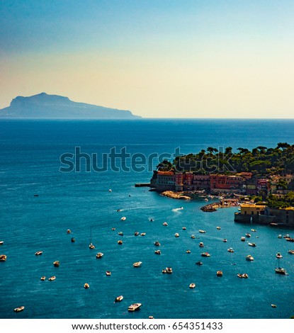 Naples bay scenic view, Italy. Travel background picture with blue sea and cityscape in golden light of evening.