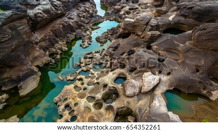 aerial photography around grand canyon in Mekong river. 3000 bok mean 3000 holes,holes eroded into the rock along Mekong river. color of water inside the holes after low tide is emerald green