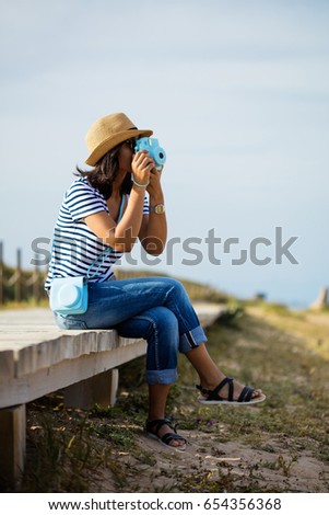 young woman taking a photo in the countryside