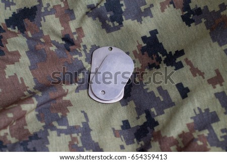 Army badge on the background of camouflage.