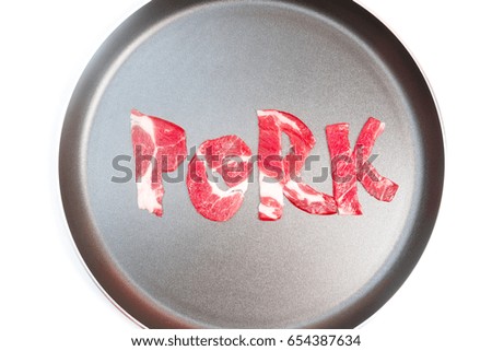 The inscription PORK on the frying pan lined with pieces of raw meat