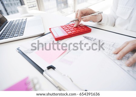 woman typing numbers on a calculator.