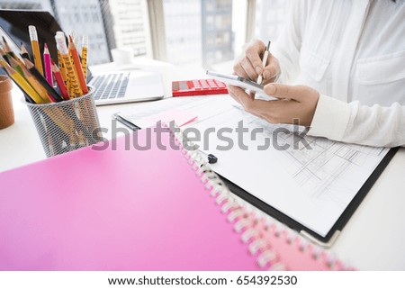 woman uses a smart phone with a touch pen.