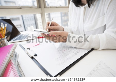 Business woman use smart phones with a stylus at work.