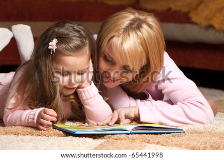 sweet  little girl with mother reading book Royalty-Free Stock Photo #65441998